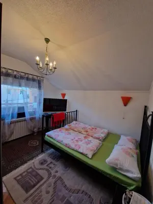 a bedroom with a bed and a chandelier at Stara Ruža in Gračanica