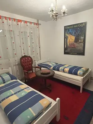 a bedroom with two beds and a table and a chair at Stara Ruža in Gračanica