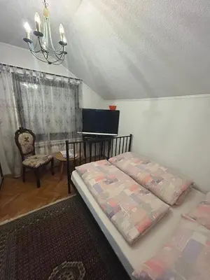 a bedroom with a bed and a table and a chair at Stara Ruža in Gračanica