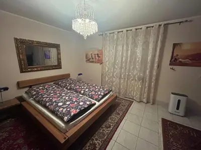 a bedroom with a bed and a chandelier at Stara Ruža in Gračanica