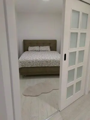 a bedroom with a bed and a door leading into a room at APARTMAN ANIKA - STAN NA DAN Doboj in Doboj