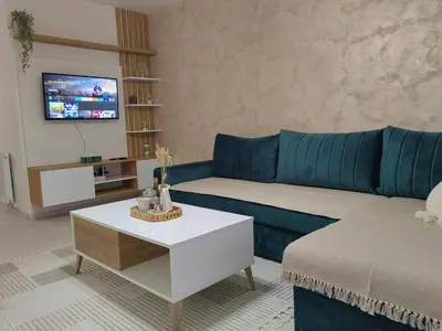 a living room with a blue couch and a coffee table at APARTMAN ANIKA - STAN NA DAN Doboj in Doboj