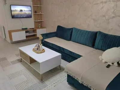 a living room with a blue couch and a table at APARTMAN ANIKA - STAN NA DAN Doboj in Doboj