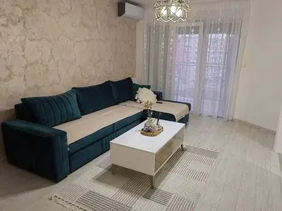 a living room with a blue couch and a table at APARTMAN ANIKA - STAN NA DAN Doboj in Doboj