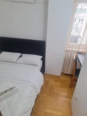 a bedroom with a white bed and a wooden floor at Luks 2 apartment in Banja Luka