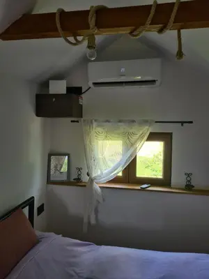 a bedroom with a bed and a window at Vikendica 