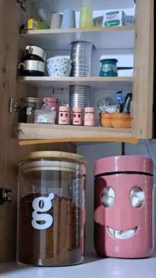 a shelf with a jar with a face drawn on it at Vikendica 