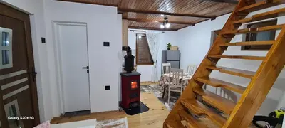 a wood stove in a room with a staircase at Vikendica 