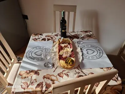 a table with a bottle of wine on top of it at Vikendica 