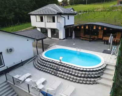 an image of a swimming pool with chairs and a house at Villa Tea - Slatina in Laktaši