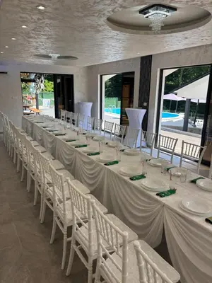 a long table in a room with white tables and chairs at Villa Tea - Slatina in Laktaši