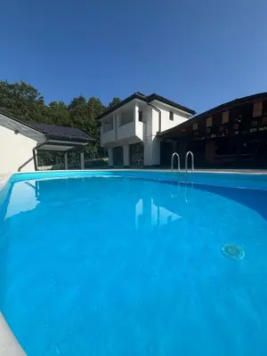 a large blue swimming pool in front of a house at Villa Tea - Slatina in Laktaši