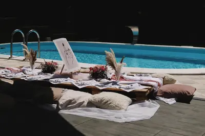 a table with pillows next to a swimming pool at Villa Tea - Slatina in Laktaši
