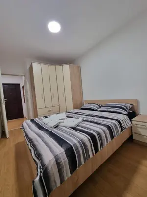 a bedroom with a large bed with a striped blanket at CityLux Doboj in Doboj