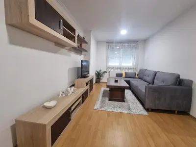 a living room with a couch and a tv at CityLux Doboj in Doboj