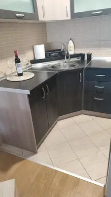 a kitchen with a sink and a counter with two wine glasses at CityLux Doboj in Doboj