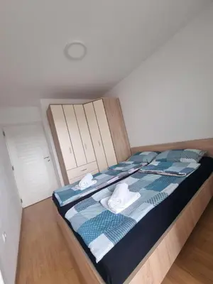 a bedroom with a bed with blue and white sheets at CityLux Doboj in Doboj