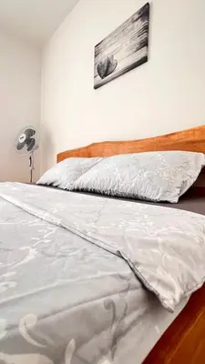 a bed with a white comforter in a bedroom at MG in Žepče
