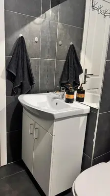 a bathroom with a white sink and a toilet at MG in Žepče