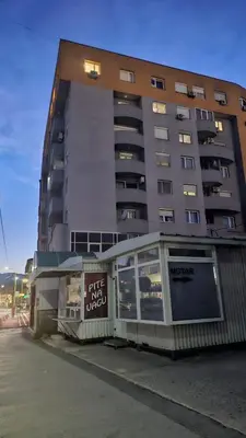 a large building with a sign in front of it at MG in Žepče