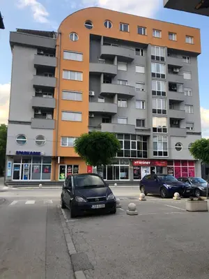 two cars parked in a parking lot in front of a building at MG in Žepče