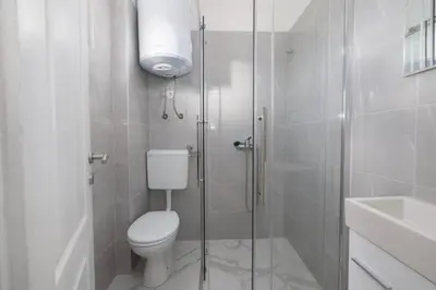 a bathroom with a toilet and a glass shower at Apartman BARIŠIĆ 1 in Kupres