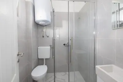 a bathroom with a toilet and a glass shower at Apartman BARIŠIĆ 1 in Kupres