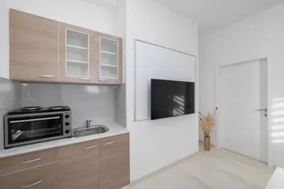 a white kitchen with a sink and a microwave at Apartman BARIŠIĆ 1 in Kupres