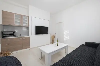 a white living room with a couch and a table at Apartman BARIŠIĆ 1 in Kupres