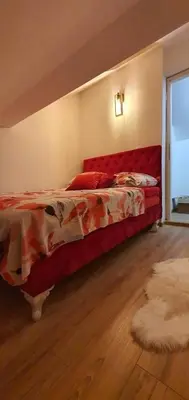 a bedroom with a bed with a red head board at Vikendica OM relax in Prijedor