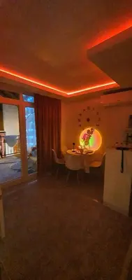 a living room with a table and a large window at Vikendica OM relax in Prijedor