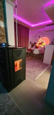 a living room with a fireplace and a dining room at Vikendica OM relax in Prijedor