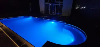 a swimming pool with blue lights in the dark at Vikendica OM relax in Prijedor