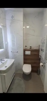 a white bathroom with a toilet and a sink at Apartman Ada Banja Luka in Rebrovac