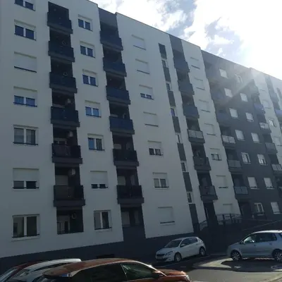 an apartment building with cars parked in front of it at Apartman Ada Banja Luka in Rebrovac