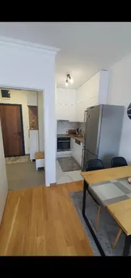 a kitchen and dining room with a table and a refrigerator at Apartman Ada Banja Luka in Rebrovac