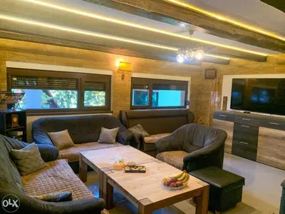 a living room with couches and a table and a tv at Villa Almedina Spa in Vlasic
