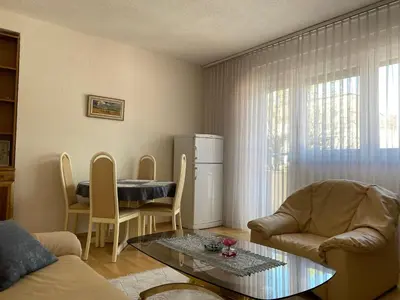 a living room with a table and chairs and a refrigerator at Apartman MARIJA in Bosanski Šamac