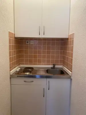 a kitchen with white cabinets and a sink at Apartman MARIJA in Bosanski Šamac