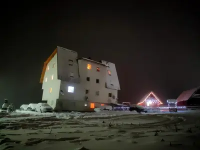 a large building in the snow at night at Apartman Vlašić Hary in Vlasic