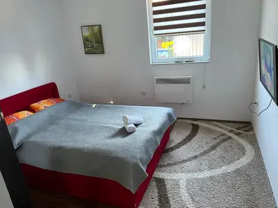 a bedroom with a bed with a towel on it at Apartman Vlašić Hary in Vlasic