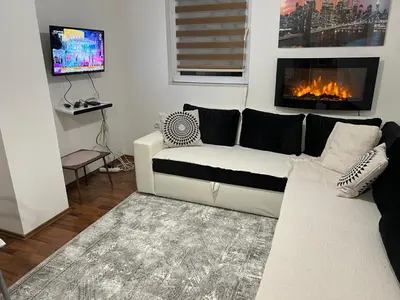 a living room with a couch and a fireplace at Apartman Vlašić Hary in Vlasic