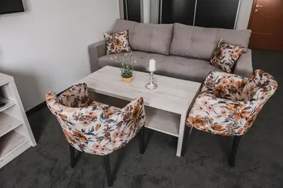 a living room with a table and chairs and a couch at Hotel Bacchus in Livno