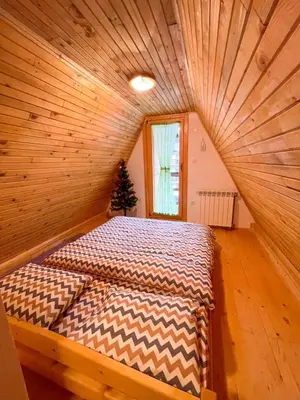 a bed in a room with a wooden ceiling at Holiday home Bella Vlašić in Šišava