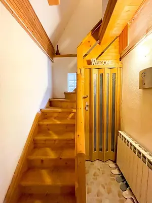 a stairway with a wooden door in a room at Holiday home Bella Vlašić in Šišava