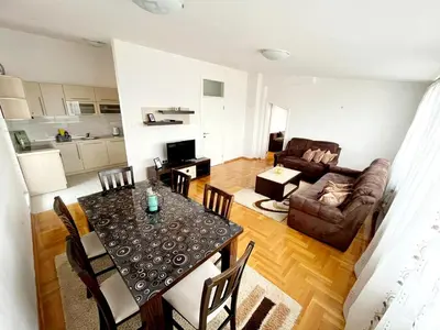 a living room with a table and a couch at Apartments Family House in Banja Luka