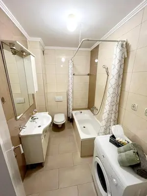 a bathroom with a sink toilet and a washing machine at Apartments Family House in Banja Luka