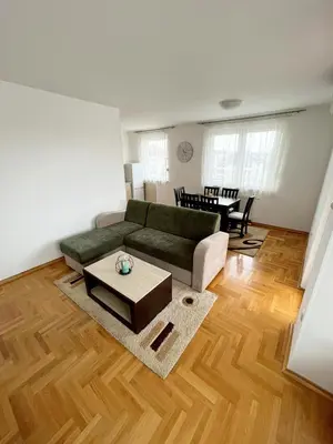 a living room with a green couch and a table at Apartments Family House in Banja Luka