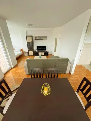 a living room with a table and a couch at Apartments Family House in Banja Luka