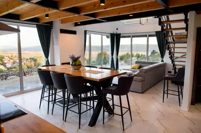 a dining room with a wooden table and chairs at Strane in Tomislavgrad
